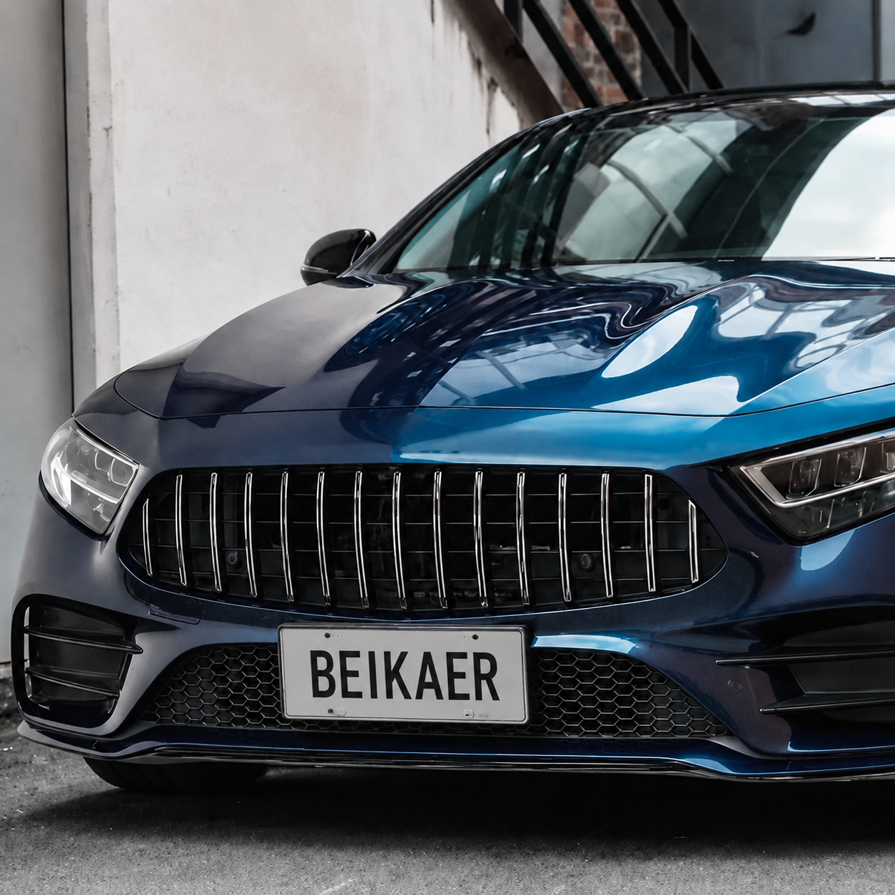 Front close-up view of a blue luxury performance car with a glossy metallic finish parked in an urban setting.