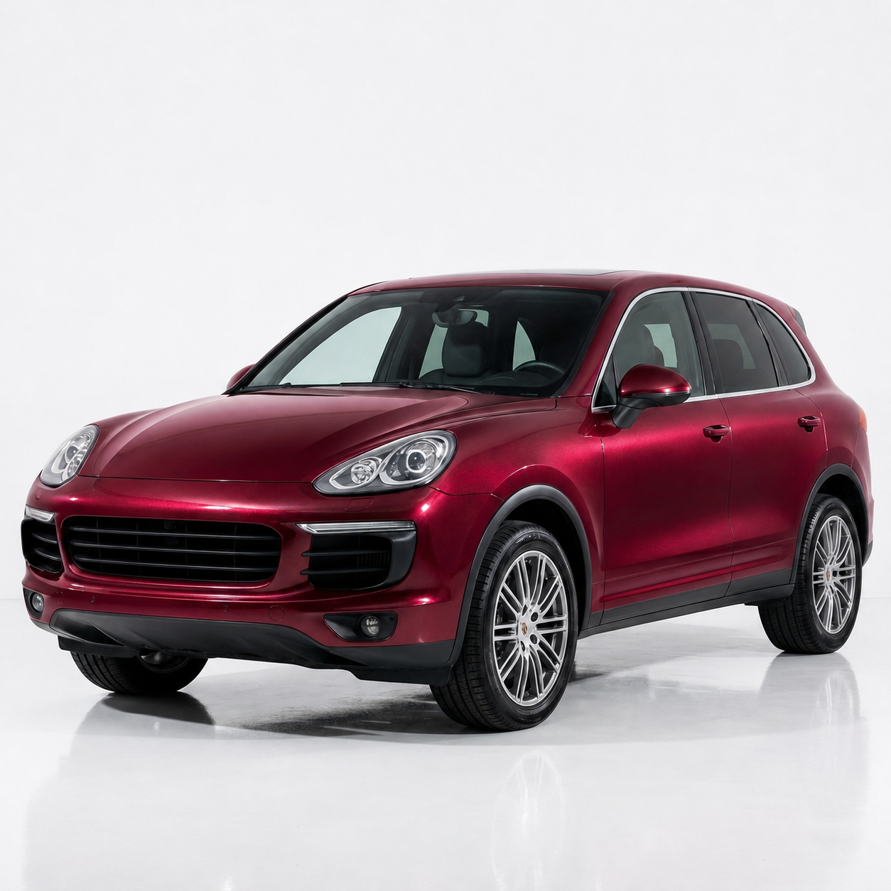 Red luxury SUV with a glossy metallic finish displayed in a professional automotive studio.